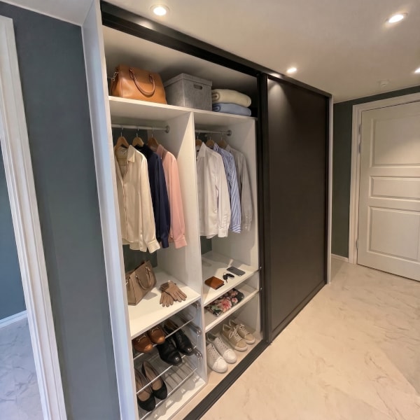 Skyvedørsgarderobe med skyvedørsfronter med svart matt glass og svarte profiler, og garderobeinnreding skreddersydd på mål