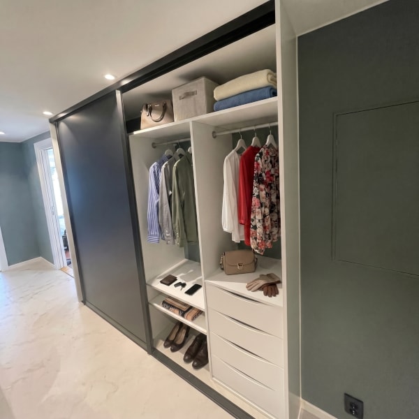 Skyvedørsgarderobe med skyvedørsfronter med svart matt glass og svarte profiler, og garderobeinnreding skreddersydd på mål