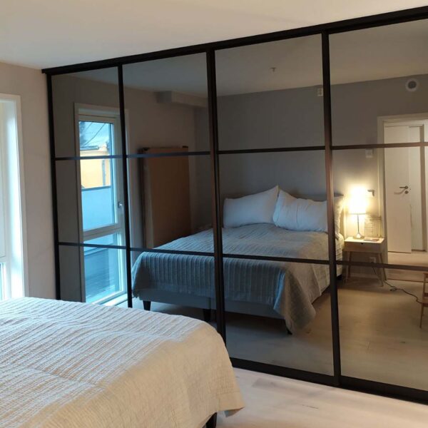 skyvedører på soverom med sotet speil og svarte profiler og sprosser
